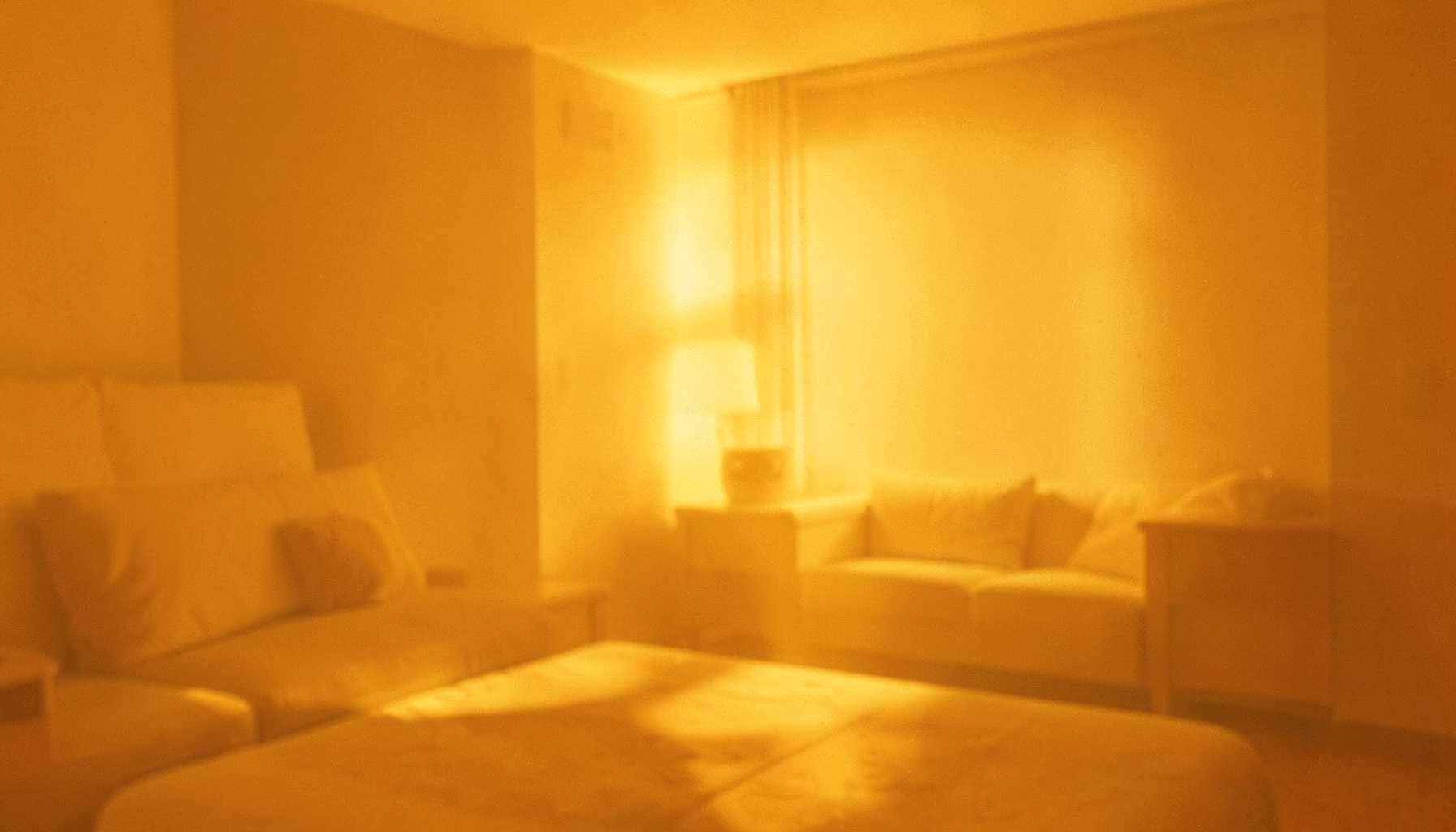 Soft golden-yellow duotone photograph of a calm interior with warm amber light and gentle shadows
